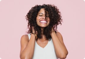 Woman touching her rich brown curly hair